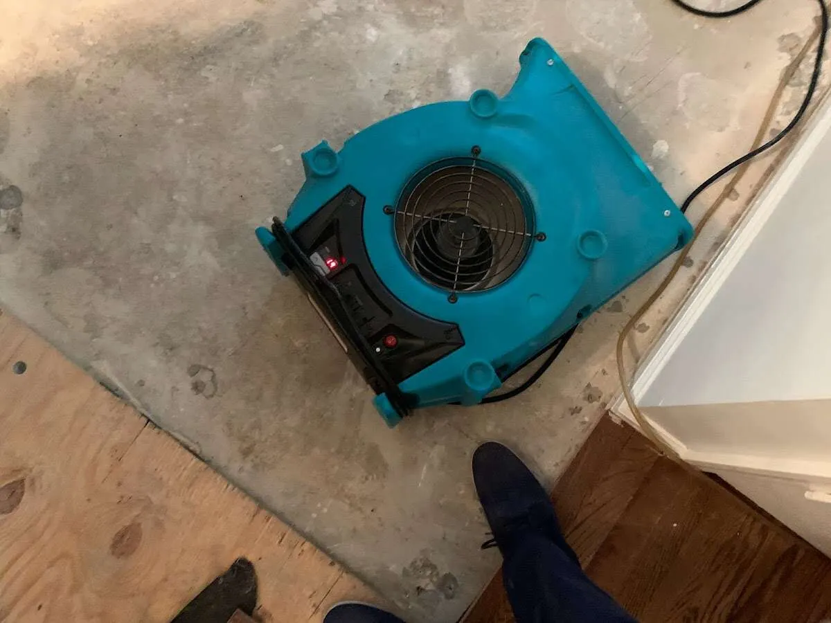 Air mover drying subfloor during Leak Detection & Repair in Fulton